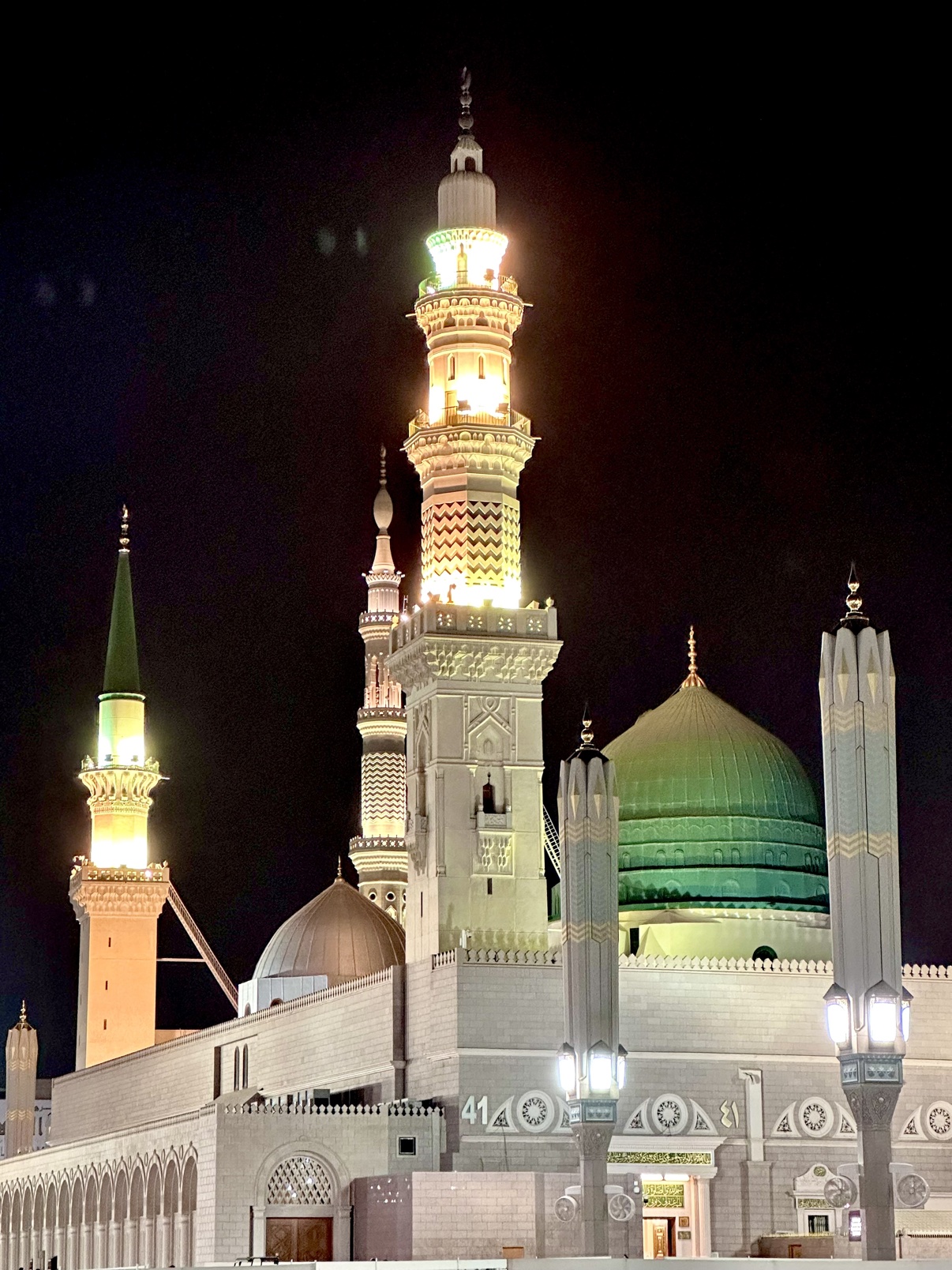 The Green Dome and illuminated minaret of the Prophet's Mosque in Madinah at night
