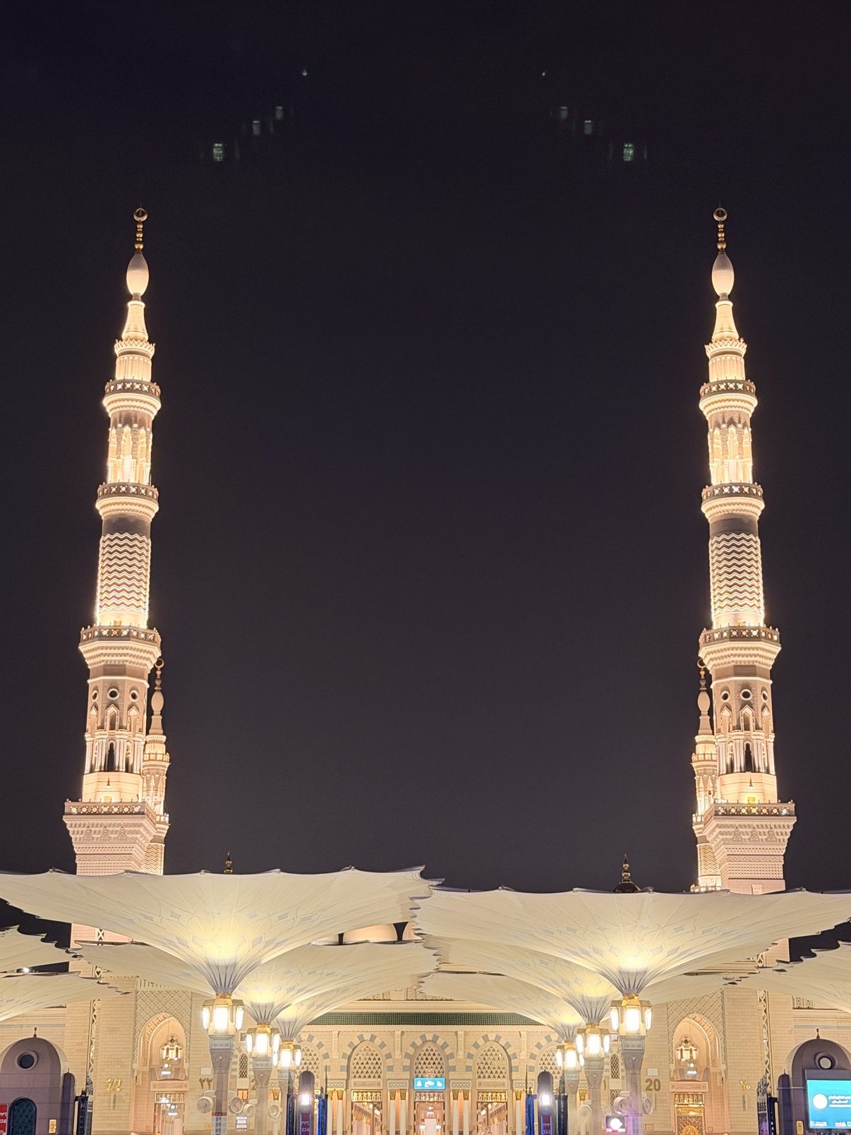 Two minarets of the Prophet's Mosque rising into the night sky