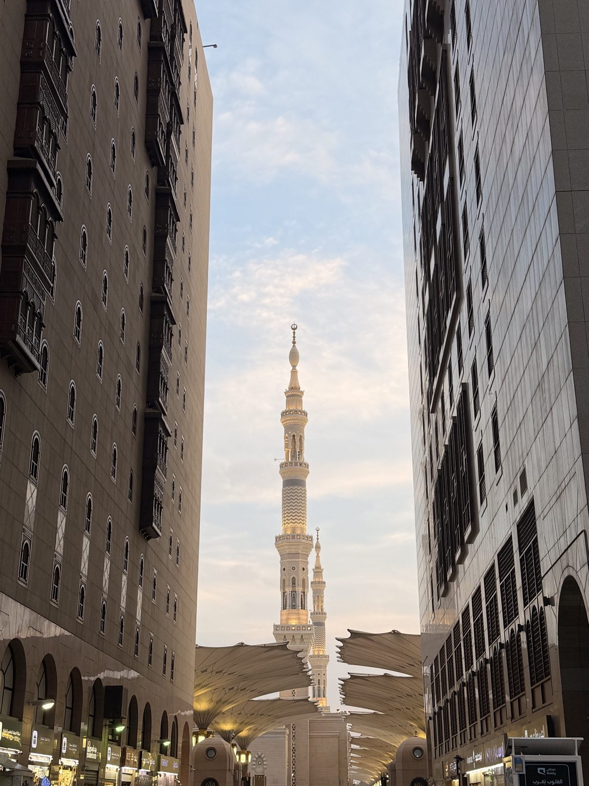 A minaret of the Prophet's Mosque seen between Madinah's buildings