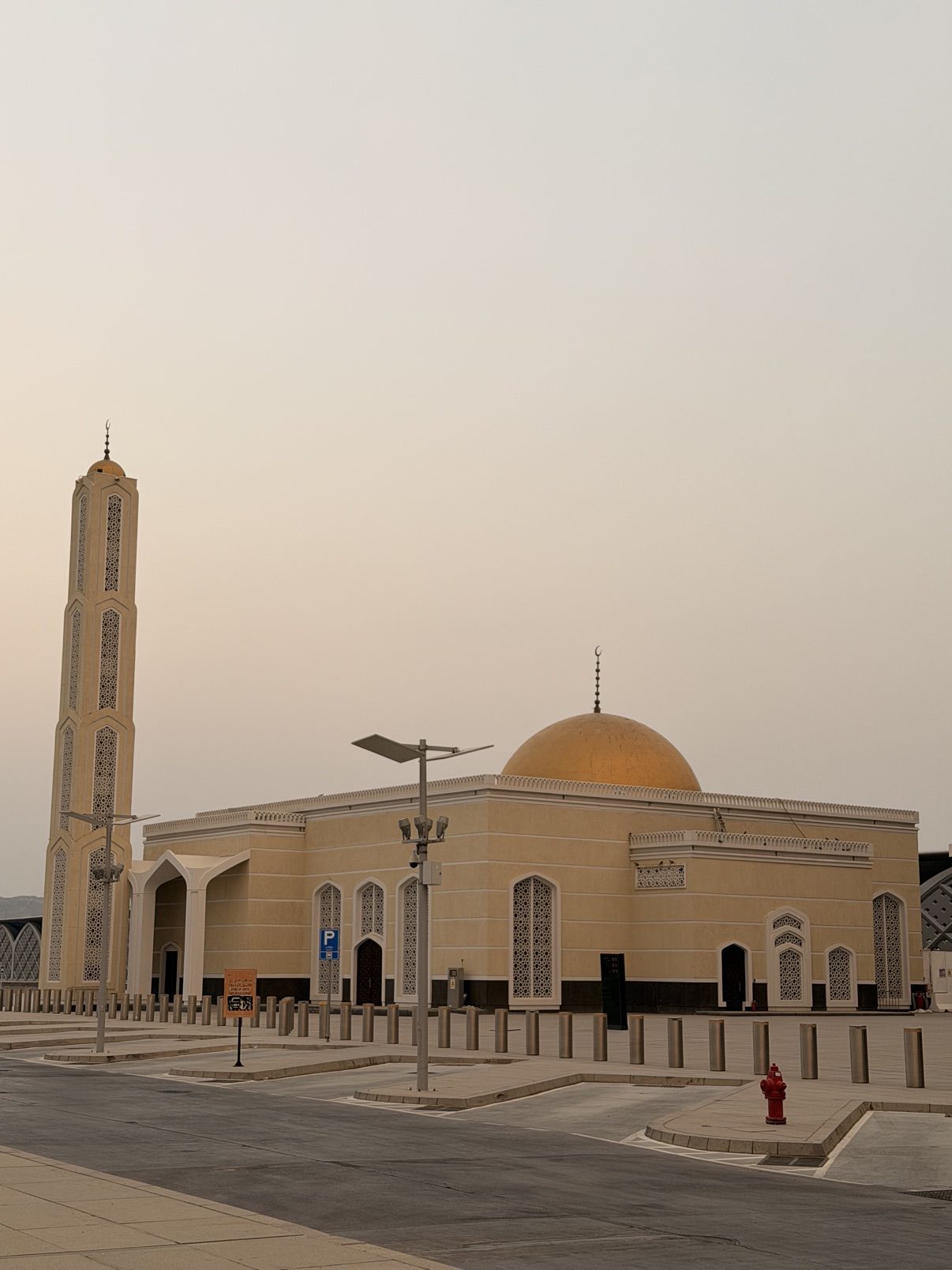 A golden-domed mosque under a hazy evening sky