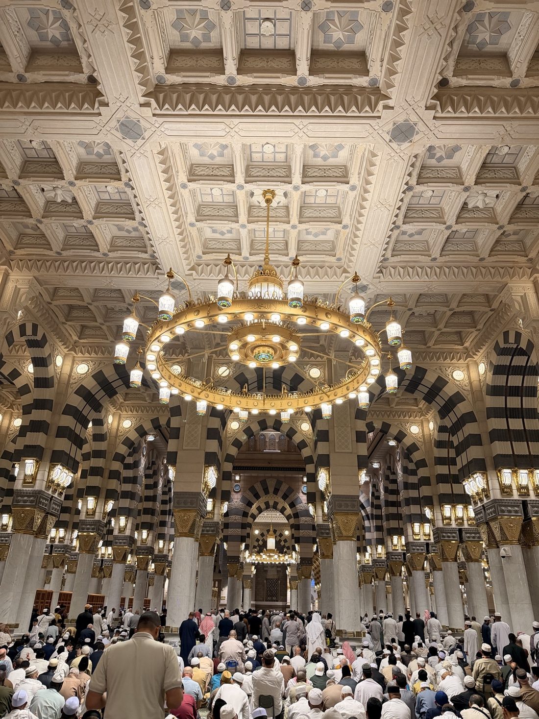 Worshippers gathered for prayer inside the Prophet's Mosque beneath a golden chandelier