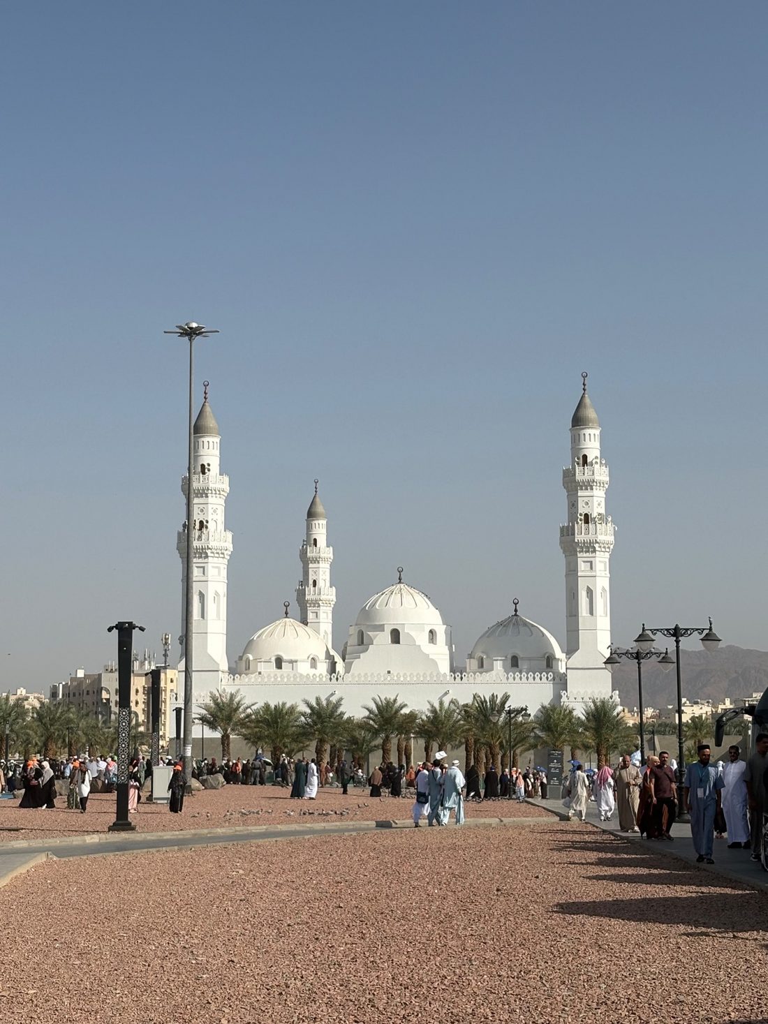 Masjid Quba with its white domes and minarets seen across the plaza